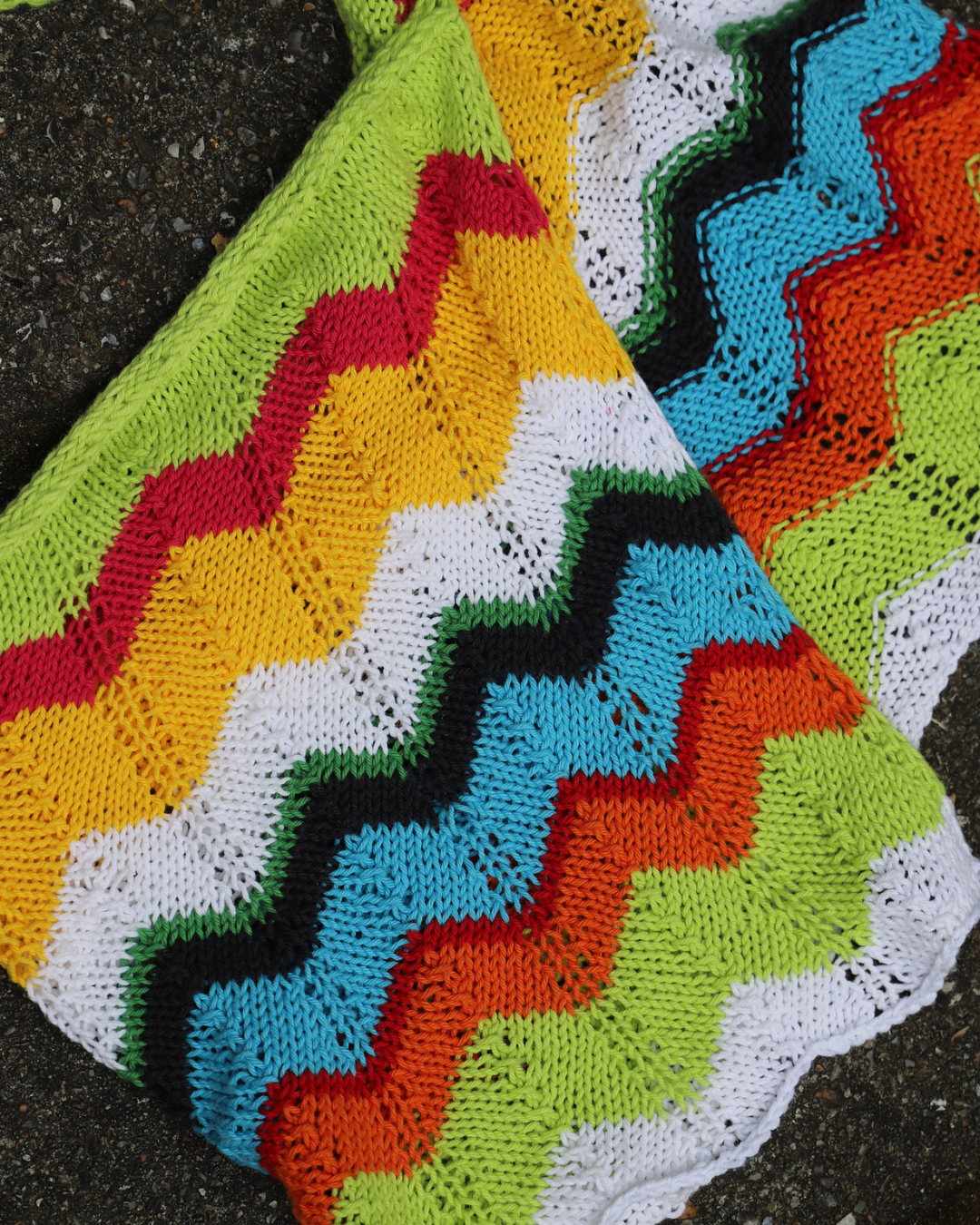 Farverigt hip scarf strikket i 8/4 bomuldsgarn med zigzagmønster og icord snor. Perfekt projekt til garnrester og sommerstrik.